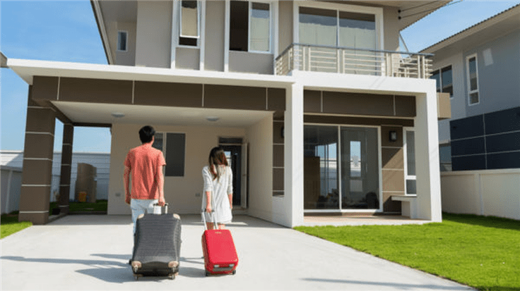 people with suitcases walking up to a vacation home