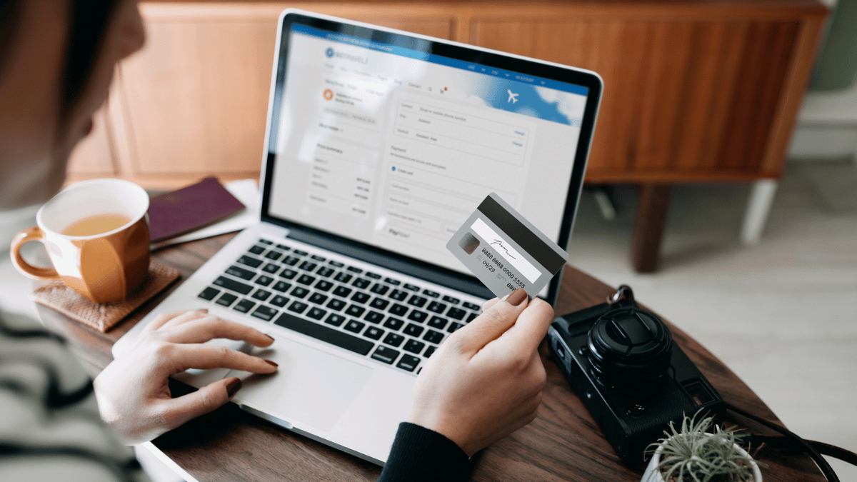 Someone looking at their credit card while at a computer